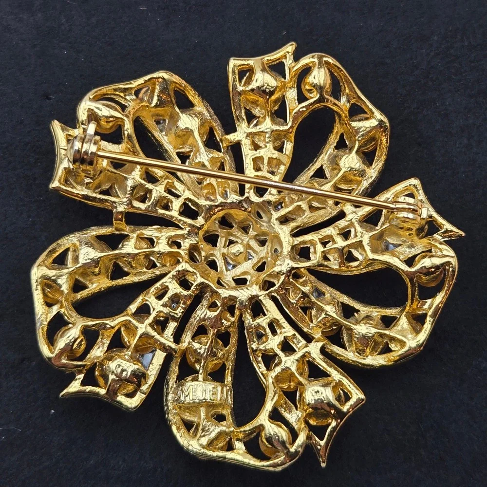 M Jent metal piece era